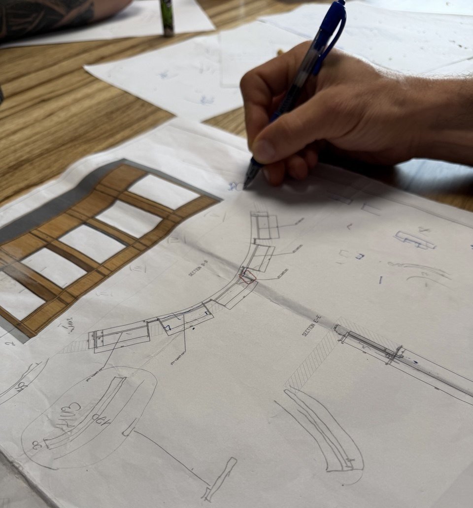 A hand sketching technical section drawings and a colored panel rendering for a woodwork project