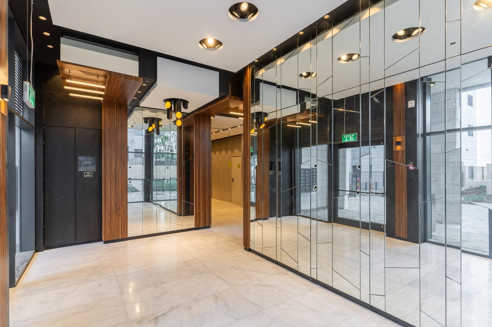 Elevator lobby wrapped in faceted mirrored panels